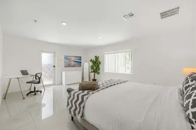 a white bedroom with a bed and a desk at Modern 4BR Retreat with Private Pool - Near Brickell in Miami