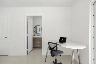 a white room with a table and a laptop on a chair at Modern 4BR Retreat with Private Pool - Near Brickell in Miami