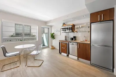 a large kitchen with a table and a refrigerator at Heart of Ocean Drive - Studio - Rooftop Pool in Miami Beach