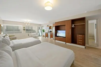 a large room with two beds and a flat screen tv at Heart of Ocean Drive - Studio - Rooftop Pool in Miami Beach