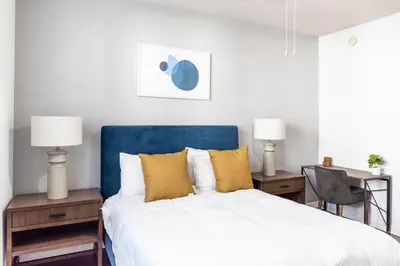 a bed with a blue headboard in a bedroom at Landing Apartments - Fort Lauderdale in Fort Lauderdale