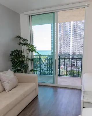 a living room with a couch and a balcony at The CAROLINE I at King David in Sunny Isles Beach in Sunny Isles Beach