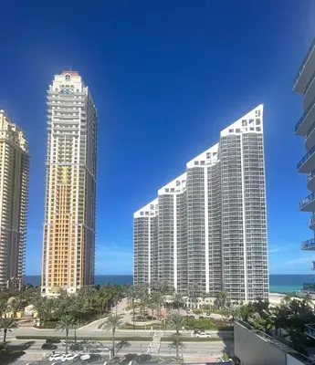 a group of tall buildings with the ocean in the background at The CAROLINE I at King David in Sunny Isles Beach in Sunny Isles Beach