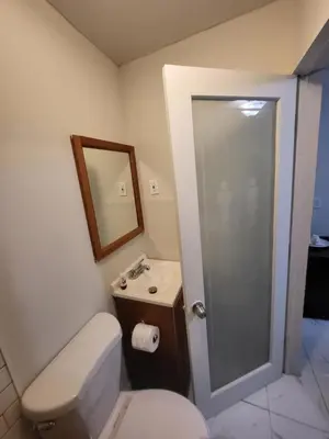 a bathroom with a toilet and a sink and a mirror at Paseo Miami in Miami