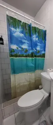 a bathroom with a toilet and a shower curtain at Paseo Miami in Miami