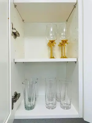 four empty glasses are sitting on a shelf at Balcony 2BR Apartment with Free Parking near Freedom Park & Brickell in Miami