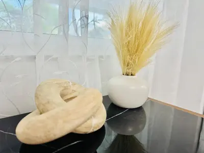 a glass table with a vase andalks of wheat at Earth-Toned Escape, Stylish Stay in Miami