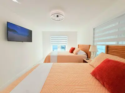 a bedroom with two beds and a flat screen tv at Ultimate Getaway Private Pool & Games Near Beach in Fort Lauderdale
