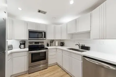 a kitchen with white cabinets and stainless steel appliances at 2BR-2BA with Pool Gym Beach Marbella Tower in Sunny Isles Beach