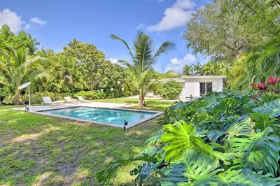a swimming pool in the yard of a house at Biscayne Park Urban Oasis with Lush Backyard! in Biscayne Park