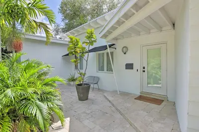 a white house with a patio with a door at Biscayne Park Urban Oasis with Lush Backyard! in Biscayne Park