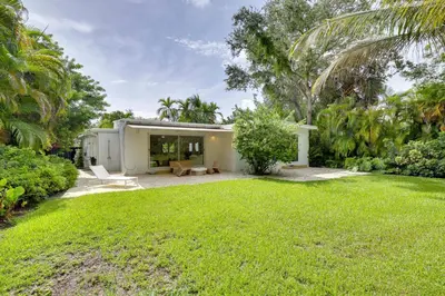 a house with a lawn in front of it at Biscayne Park Urban Oasis with Lush Backyard! in Biscayne Park