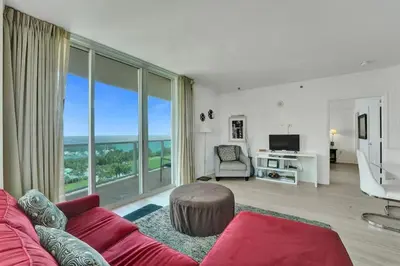 a living room with a red couch and a large window at Spacious 2BR in Miami Bay Views plus Balcony in Miami