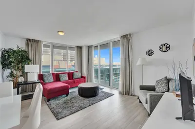 a living room with red furniture and a large window at Spacious 2BR in Miami Bay Views plus Balcony in Miami