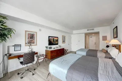 a hotel room with two beds and a desk and a computer at Arya Hotel Studio Views plus Kitchenette plus Parking in Miami