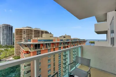 a balcony with a chair and some buildings at Arya Hotel Studio Views plus Kitchenette plus Parking in Miami