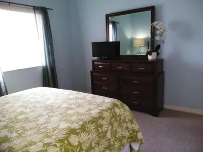 a bedroom with a bed and a dresser with a mirror at Charming Kendall Home in Kendall