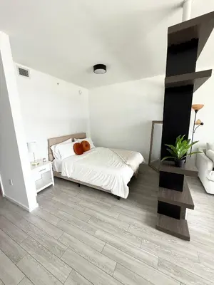 a bedroom with a bed with a teddy bear on it at Downtown Miami Luxe Studio Suite in Miami