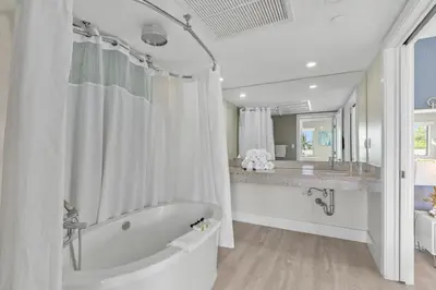 a white bathroom with a tub and a sink at Spacious Studio with Roof Top Pool & Bar in Miami Beach