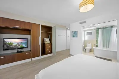 a bedroom with a tv and a bed and a tub at Ocean Drive Studio - Walk to the beach Rooftop Pool in Miami Beach