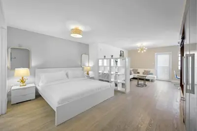 a white bedroom with a white bed and a living room at Ocean Drive Studio - Walk to the beach Rooftop Pool in Miami Beach