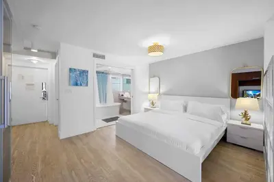 a white bedroom with a white bed and a bathroom at Ocean Drive Studio - Walk to the beach Rooftop Pool in Miami Beach