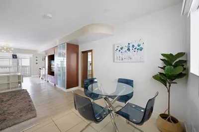 a dining room with a glass table and chairs at Spacious Studio - Roof Top Pool & Bar South Beach in Miami Beach