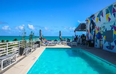 a swimming pool with the ocean in the background at Spacious Studio - Roof Top Pool & Bar South Beach in Miami Beach