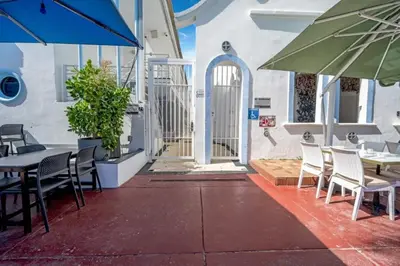 a patio with tables and chairs and an umbrella at Ocean Drive Studio with Rooftop Pool Prime Location in Miami Beach