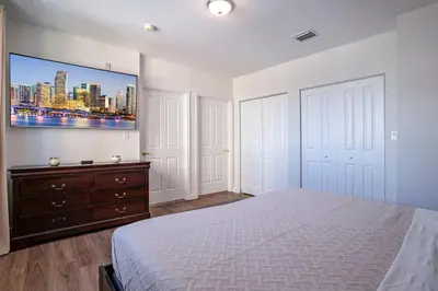 a bedroom with a bed and a tv on the wall at Large Apt, Parking, Split King Bed, Washer & Dryer in Miami