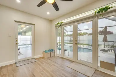 a living room with a ceiling fan and sliding glass doors at Backyard Oasis Fort Lauderdale Home Near Beach in Fort Lauderdale