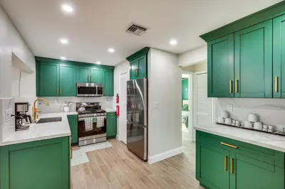 a kitchen with green cabinets and a refrigerator at Backyard Oasis Fort Lauderdale Home Near Beach in Fort Lauderdale