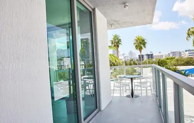 a balcony with a table and chairs on a building at Stylish 2BR Quadro Luxe Stay in Design District in Miami
