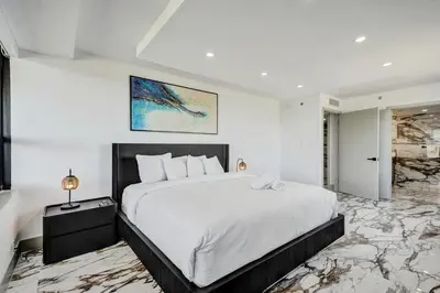 a bedroom with a large bed in a room with marble floors at Luxury Beachside 3BR 3BA Condo Resort Amenities Pools Gym and Sauna 620 in Miami Beach