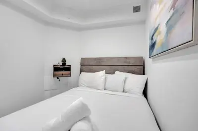 a white bedroom with a white bed with white pillows at Oceanside Paradise Escape Spacious and Scenic Resort amenities Pools Bar Sauna 1514 in Miami Beach