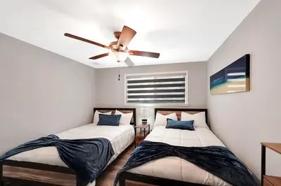 two beds in a room with a ceiling fan at Waterfront Retreat Home Dania Beach in Dania Beach