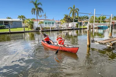 two people in a red boat in the water at Waterfront Retreat Home Dania Beach in Dania Beach