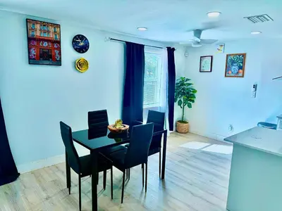 a dining room with a black table and chairs at Serene 3-Bedroom renovated house with AC in Fort Lauderdale in Fort Lauderdale