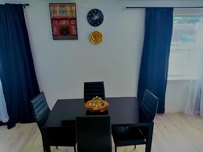a dining room table with chairs and a clock on the wall at Serene 3-Bedroom renovated house with AC in Fort Lauderdale in Fort Lauderdale