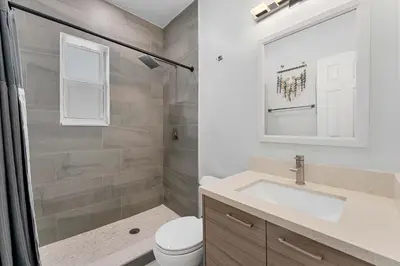 a bathroom with a toilet and a sink and a mirror at Modern 3 BR Villa Near Beach & FLL in Hollywood