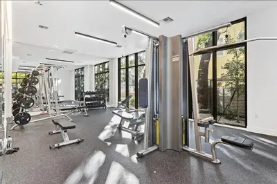 a gym with several treadmills and machines and windows at Luxury Pent House Suite with Downtown Views in Miami