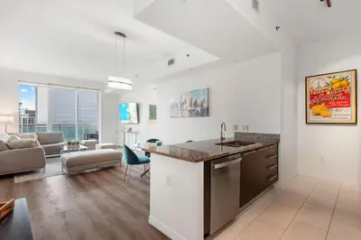 a kitchen and living room with a sink and a couch at 47th-Floor Brickell Condo with City Views and Pool in Miami