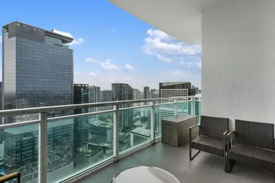 a balcony with two chairs and a view of a city at 47th-Floor Brickell Condo with City Views and Pool in Miami