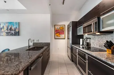 a kitchen with granite counter tops and stainless steel appliances at 47th-Floor Brickell Condo with City Views and Pool in Miami