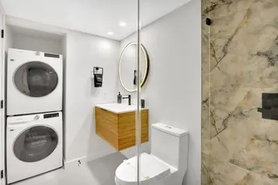 a bathroom with a washing machine and a sink at Stylish Renovated 3BR Condo Bay Views plus Parking in Miami