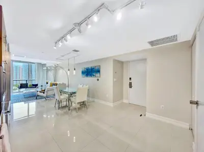 a dining room and living room with a table and chairs at Icon Brickell 20th Floor 1BR Pool View Balcony in Miami