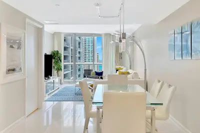 a dining room with a glass table and chairs at Icon Brickell 20th Floor 1BR Pool View Balcony in Miami