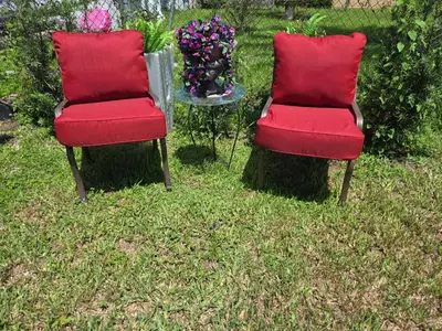 two red chairs sitting in the grass with flowers at Little Wynwood Oasis in Miami