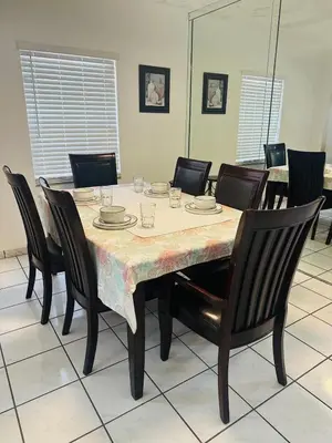 a dining room table with chairs and a tablecloth on it at Love Story Pool House, free parking & BBQ in Miami