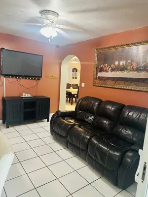 a living room with a leather couch and a flat screen tv at Love Story Pool House, free parking & BBQ in Miami
